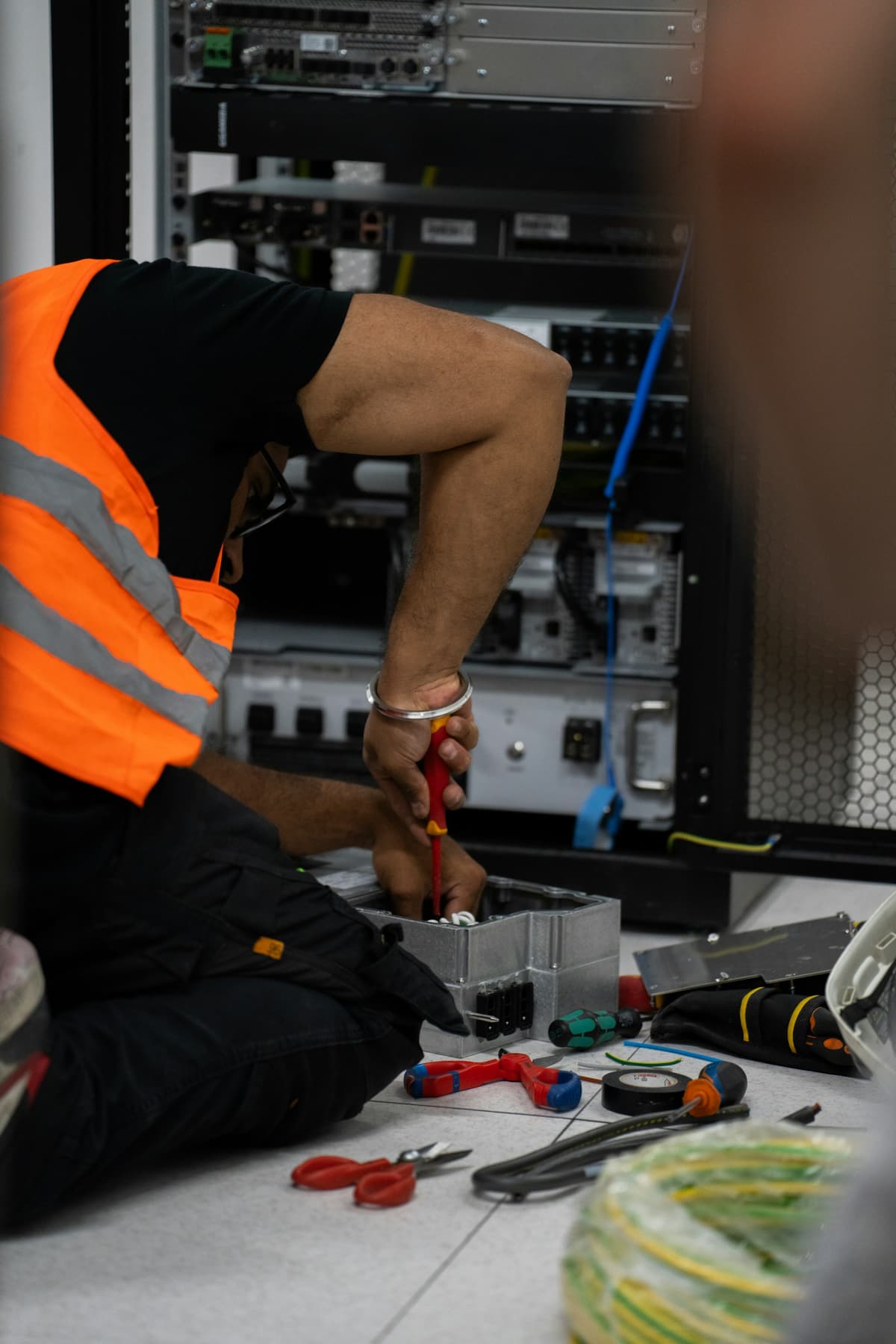 A technician cabling equipment inside a server rack